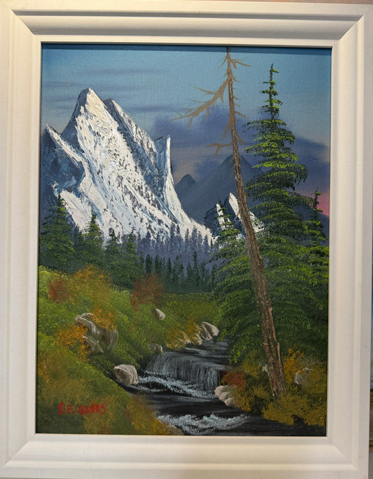 Oil painting on 12x16 canvas set within white frame, landscape with creek, trees and mountain range.